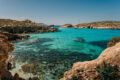 Blue Lagoon, Comino, Malta, with turquoise water, limestone cliffs, and boats anchored in a sheltered bay