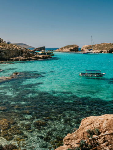Blue Lagoon, Comino, Malta, with turquoise water, limestone cliffs, and boats anchored in a sheltered bay