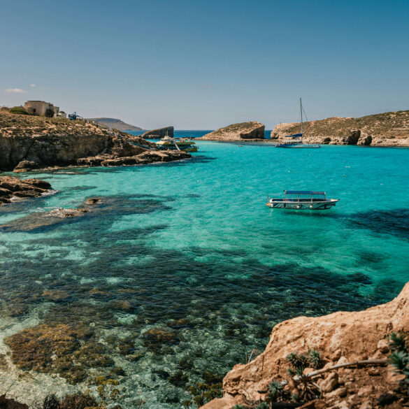 Blue Lagoon, Comino, Malta, with turquoise water, limestone cliffs, and boats anchored in a sheltered bay