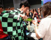 A sake brewer in a traditional Japanese haori jacket pours a sample for a visitor at Sake Festival Singapore.
