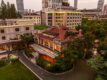 67 Pall Mall's Grand Mansion in Shanghai at dusk, with a red-tiled roof, glass conservatory and skyline backdrop.