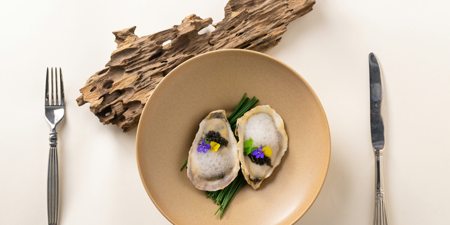 Oysters with caviar and edible flowers, a fine dining dish from Singapore's fine dining restaurant scene