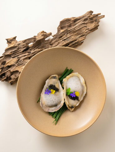Oysters with caviar and edible flowers, a fine dining dish from Singapore's fine dining restaurant scene