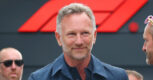 Christian Horner smiles in a navy shirt in front of an F1 logo backdrop, ahead of his Singapore live event Unfiltered
