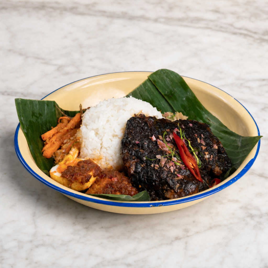 Buah Keluak Chicken served with rice, sambal and sides at Nyonya Next Door