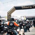 Motorcyclists ride under the checkered Wicked by Choice arch at Wicked Wallop Drop in Singapore.