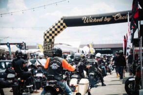Motorcyclists ride under the checkered Wicked by Choice arch at Wicked Wallop Drop in Singapore.