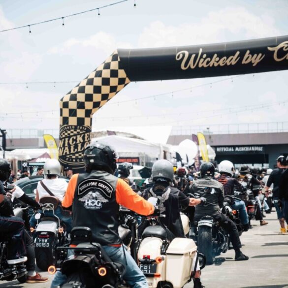 Motorcyclists ride under the checkered Wicked by Choice arch at Wicked Wallop Drop in Singapore.