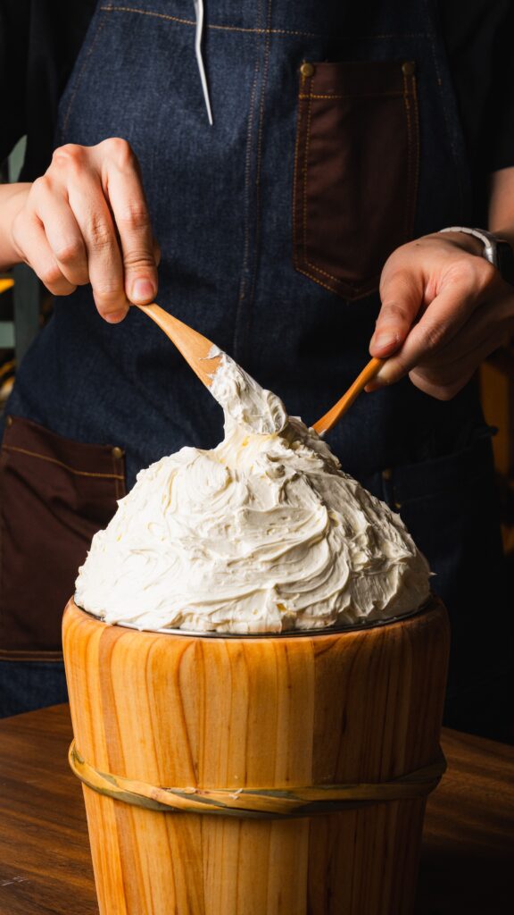 A chef whipping a large mound of salted butter with wooden spatulas at Assaggi.