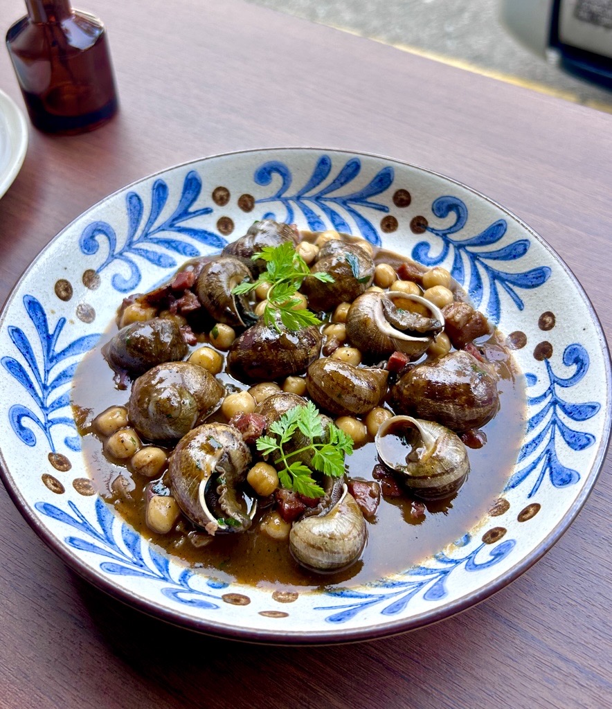 A plate of traditional Spanish snails with chickpeas and herbs, served at Casa Lola.