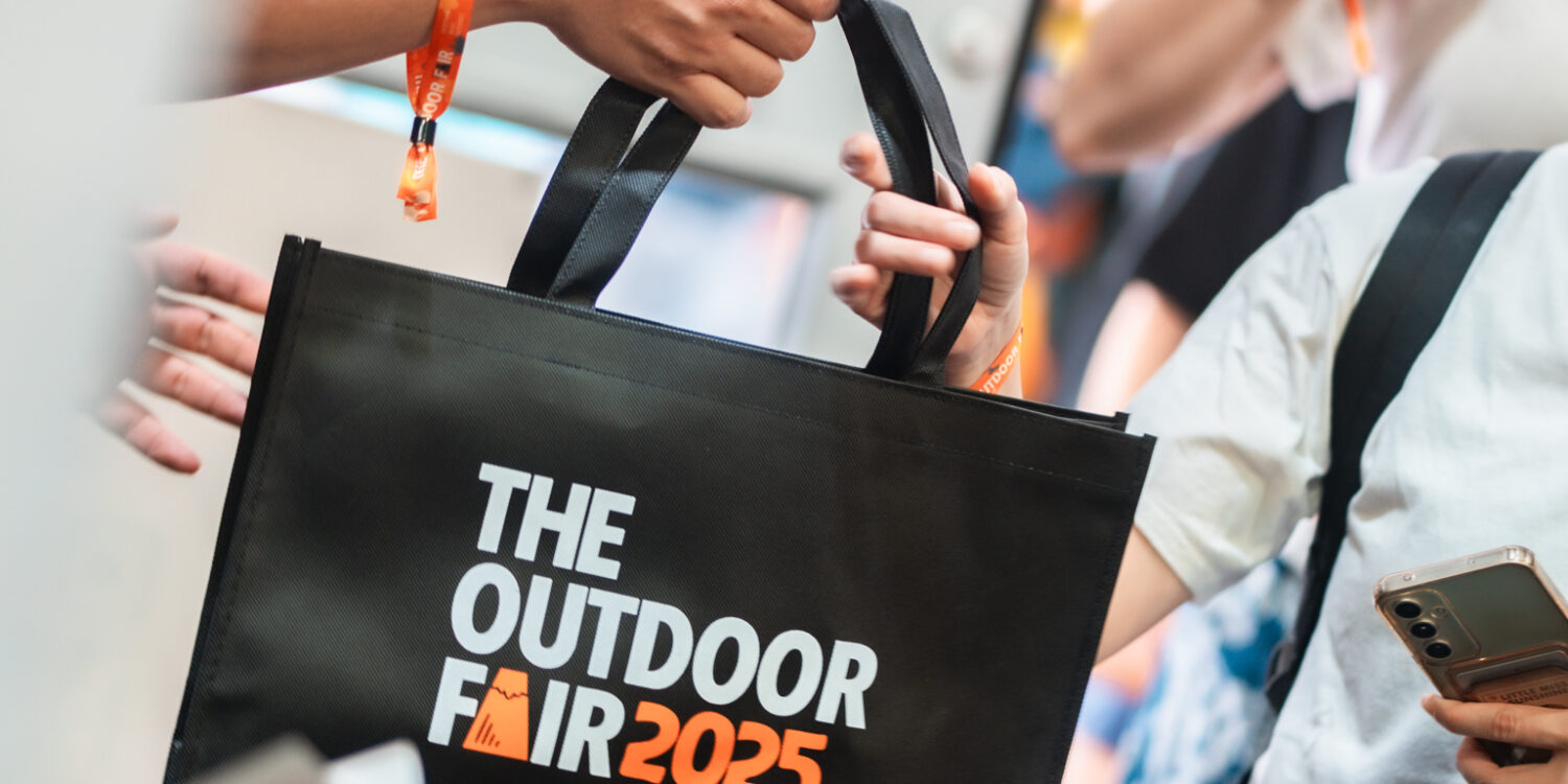 An attendee receives a black tote bag at the past event registration.
