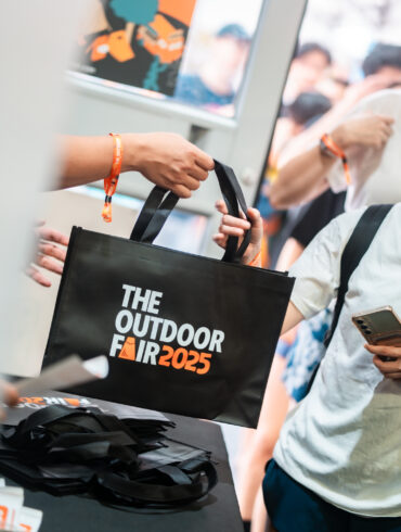 An attendee receives a black tote bag at the past event registration.