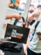 An attendee receives a black tote bag at the past event registration.