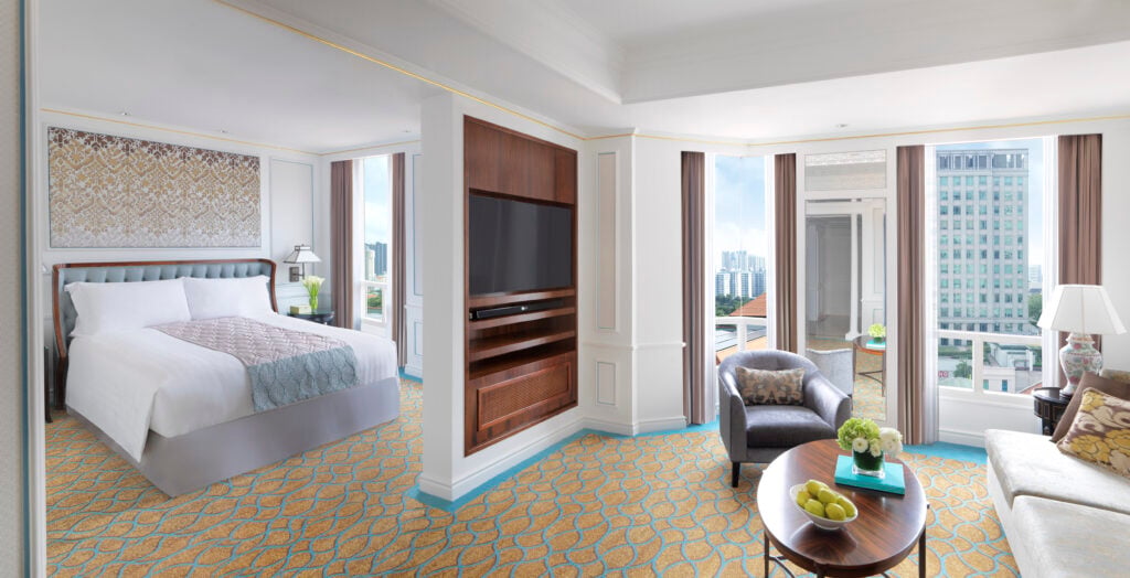 Junior Suite bedroom and lounge area at Frasers House, a Luxury Collection Hotel, Singapore, with city skyline views