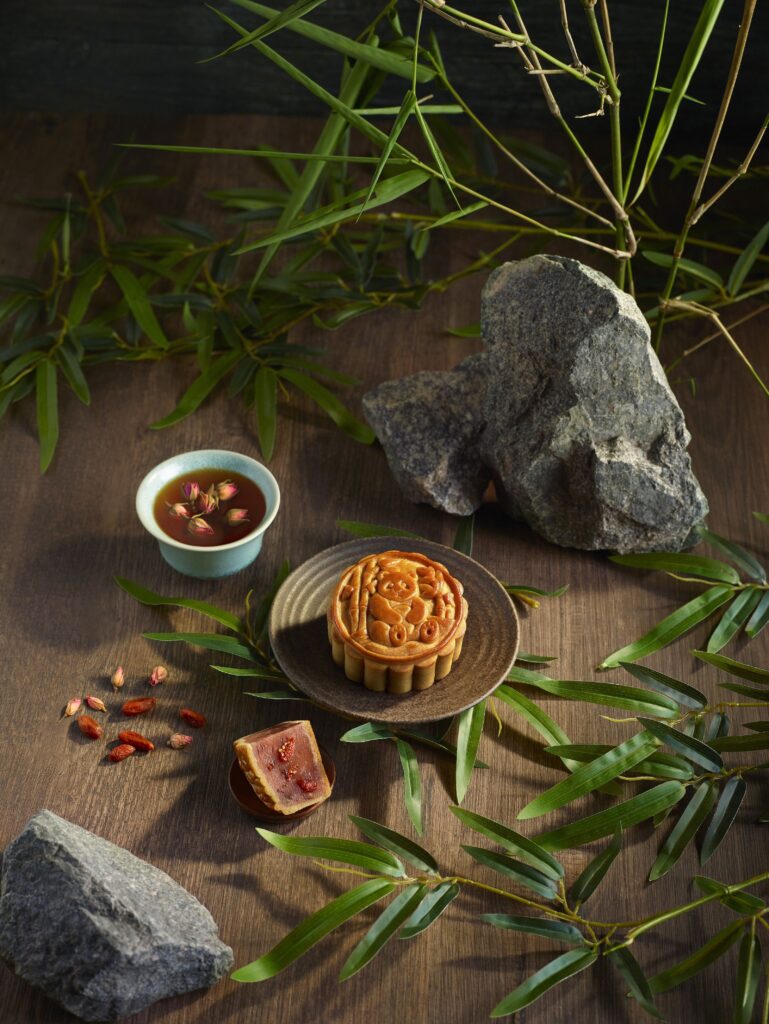 Panda motif baked mooncake on ceramic plate with rose tea and wolfberries, Mandai Rainforest Resort Mid-Autumn 2026 collection
