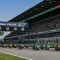 MotoGP riders take the start at Chang International Circuit in Buriram, Thailand, with a packed grandstand behind