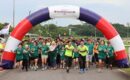 Runners of all abilities crossing the start arch at Runninghour's Run For Inclusion, cheering as they set off from Bedok Reservoir