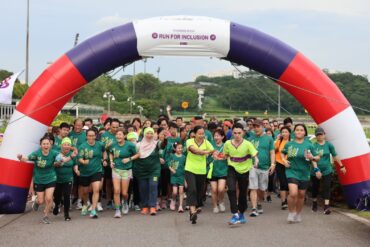 Runners of all abilities crossing the start arch at Runninghour's Run For Inclusion, cheering as they set off from Bedok Reservoir