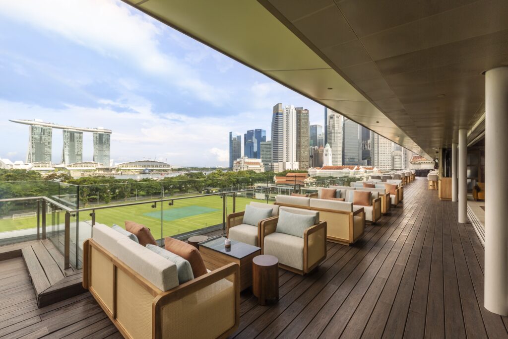 An outdoor lounge deck at Xava Skybar with views of the Marina Bay skyline.