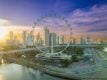 Aerial view of the Singapore Flyer and Marina Bay skyline at sunrise, with the Marina Bay Street Circuit track visible below