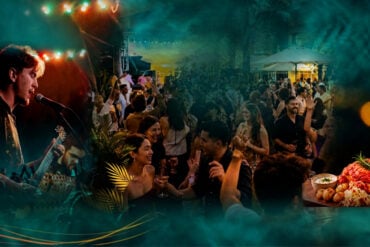 Live band performing and crowd dancing at Good Times Festival's outdoor terrace at South Beach Singapore, with a sharing platter in the foreground.