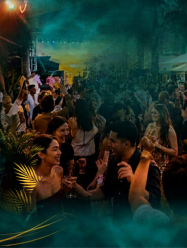 Live band performing and crowd dancing at Good Times Festival's outdoor terrace at South Beach Singapore, with a sharing platter in the foreground.
