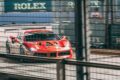 A race car speeding past Rolex signage on the Marina Bay Street Circuit during Singapore Grand Prix weekend