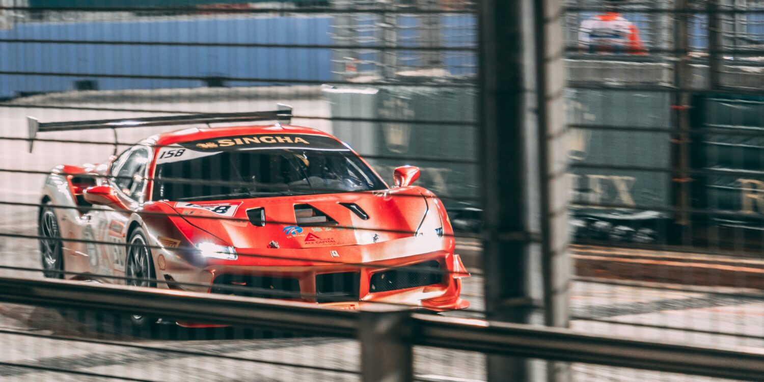 A race car speeding past Rolex signage on the Marina Bay Street Circuit during Singapore Grand Prix weekend