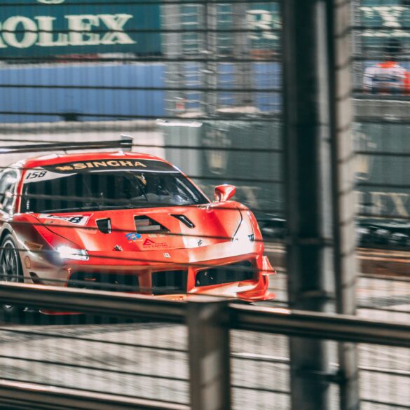 A race car speeding past Rolex signage on the Marina Bay Street Circuit during Singapore Grand Prix weekend