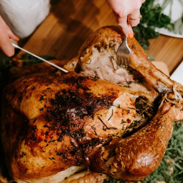 Hands carving a herb-crusted roast turkey for Christmas takeaways 2026 in Singapore