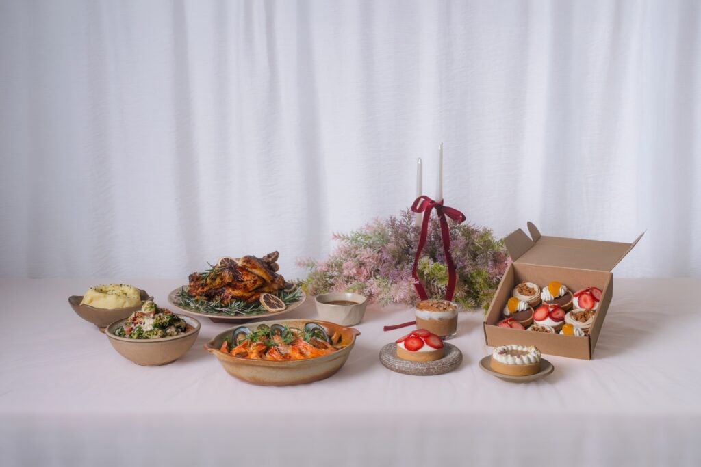 Lola’s Christmas Feast with Free-range Roast Chicken, Seafood Stew, Broccoli Caesar Salad and Mashed Potatoes beside a box of Christmas tarts