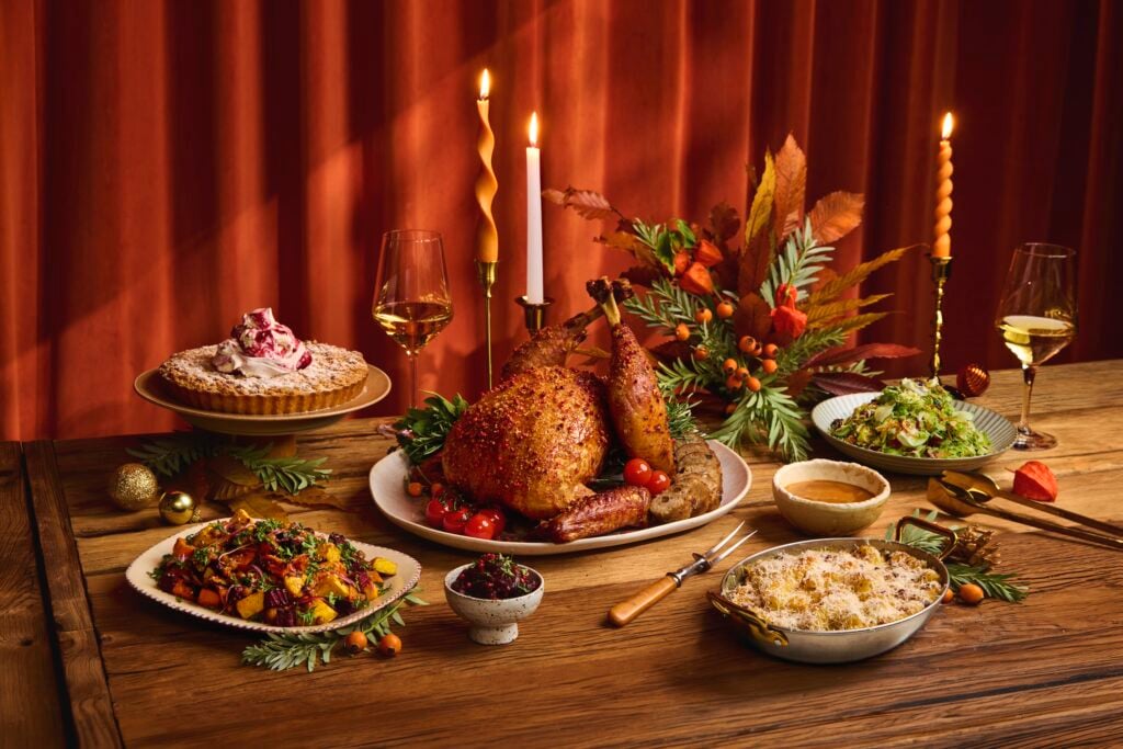 Meadesmoore’s Smoked Honey Mustard Glazed Turkey Two Ways with Chestnut and Rum-Infused Sultana Stuffing, Mac & Cheese, Roasted Squash & Beetroot, Shaved Brussels Sprouts Salad and Wild Berry Pie on a candlelit table