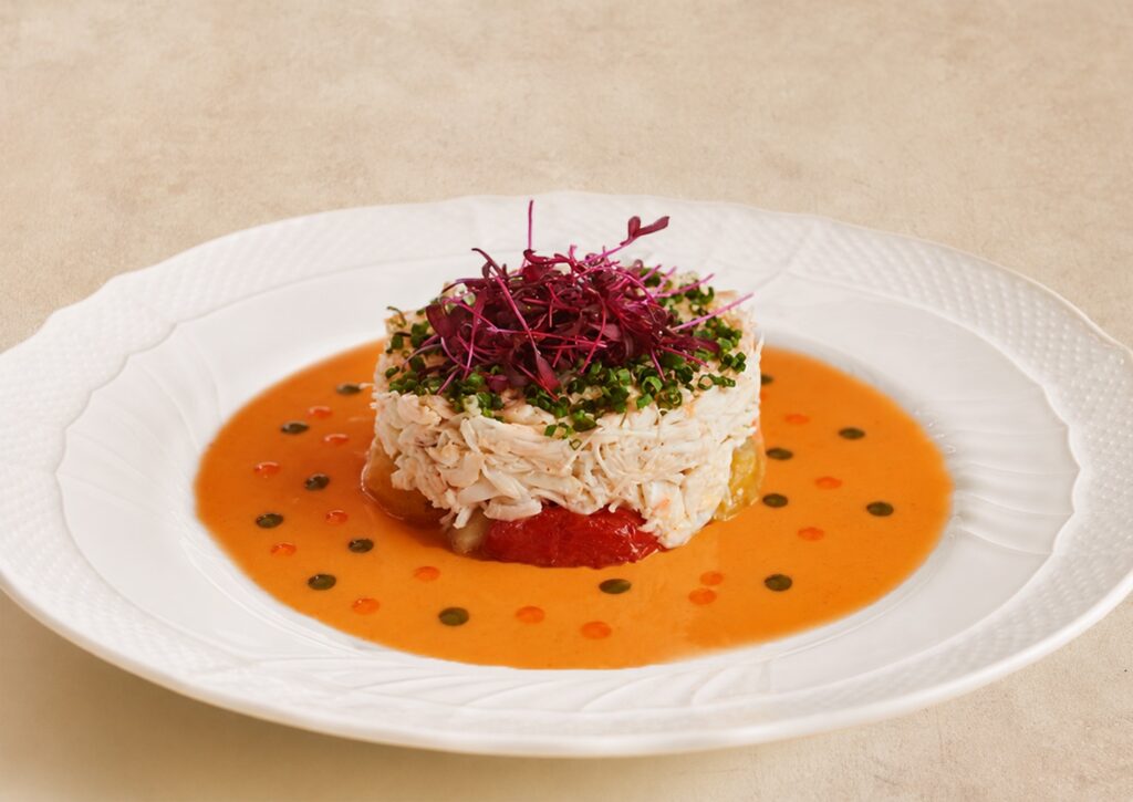 Insalata di Granchio at Sospiri, a stack of jumbo lump crab over tomatoes in an orange sauce with micro herbs.