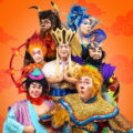 Cast of Wild Rice’s Monkey Goes West in costume as Ah Tang, the Monkey King, Pigsy, Sandy, Red Boy, King Bull and Princess Iron Fan against an orange cloud backdrop