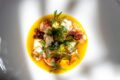 Seared langoustines with pineapple, crisp seaweed and fresh herbs in a golden yellow sauce, for new restaurants in Singapore September 2026.