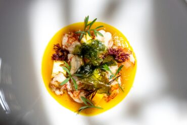 Seared langoustines with pineapple, crisp seaweed and fresh herbs in a golden yellow sauce, for new restaurants in Singapore September 2026.
