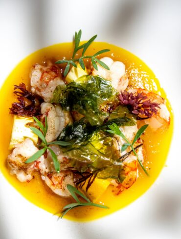 Seared langoustines with pineapple, crisp seaweed and fresh herbs in a golden yellow sauce, for new restaurants in Singapore September 2026.